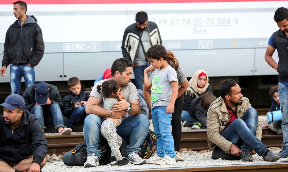 Syriske flyktninger venter ved et jernbanespor i Kroatia. De ønsker å dra til et nordeuropeisk land. Bildet er tatt i midten av september i år. Foto: iStockphoto